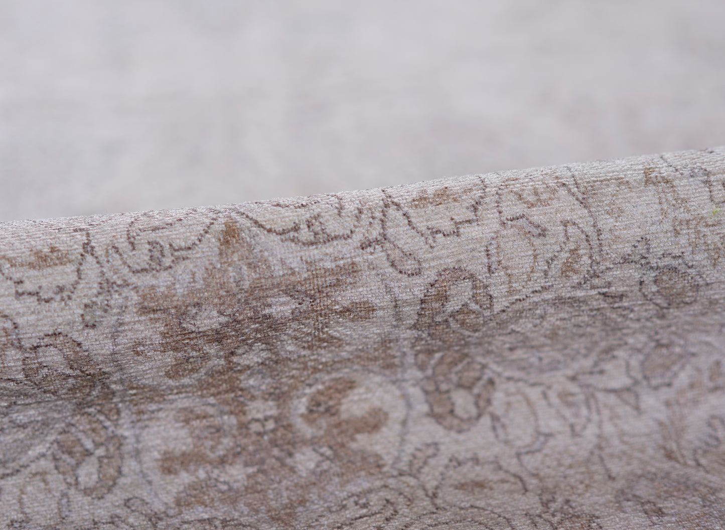 Taupe-gray damask patterned rug with a soft velvety texture and floral scroll design, 2' x 3'.