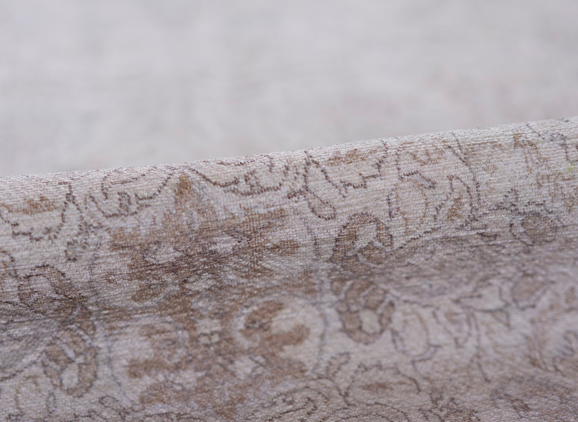 Taupe-gray damask patterned rug with a soft velvety texture and floral scroll design, 2' x 3'.