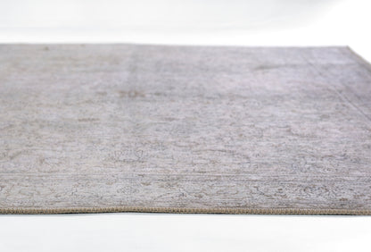 Gray patterned area rug with subtle mottled design, low-pile, rectangular, edge visible along bottom.
