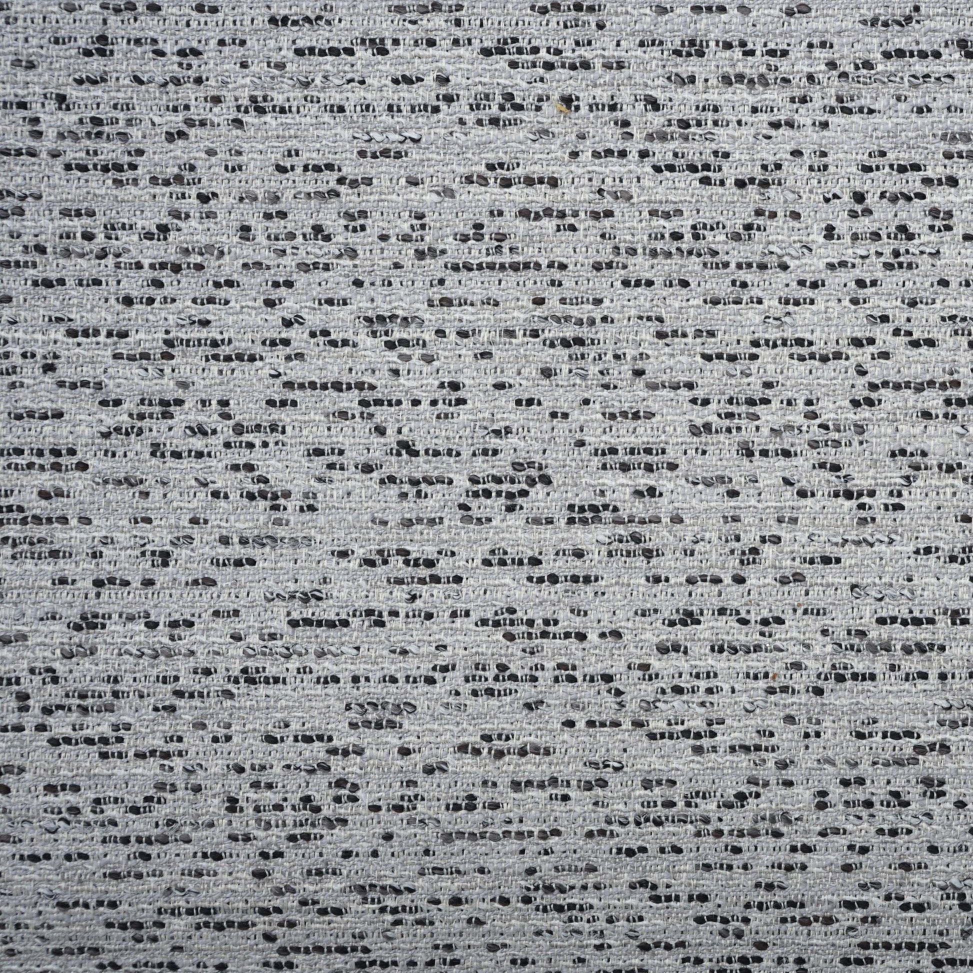 Grey dotted boucle fabric with tiny black specks and a textured woven surface.