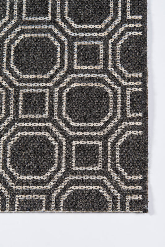 Charcoal woven runner rug with cream interlocking squares and rounded octagons in a geometric pattern.