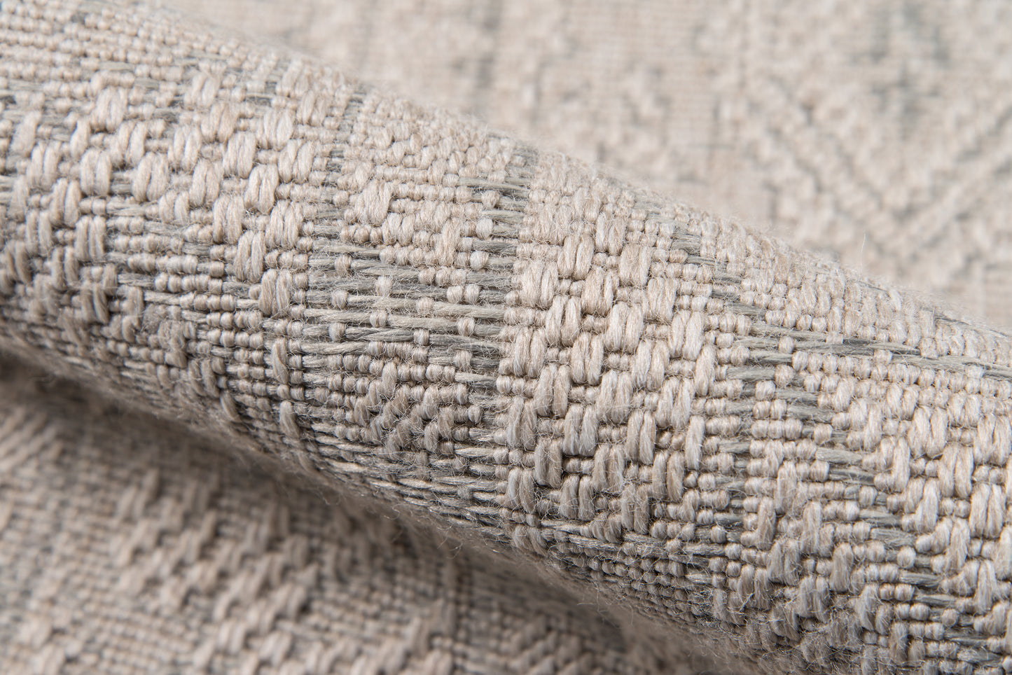 Close-up of gray & beige woven rug fabric with a textured geometric pattern; thick, cozy runner rug.