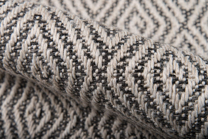 Close-up of gray and black chevron-patterned woven rug, 2' x 10' runner.