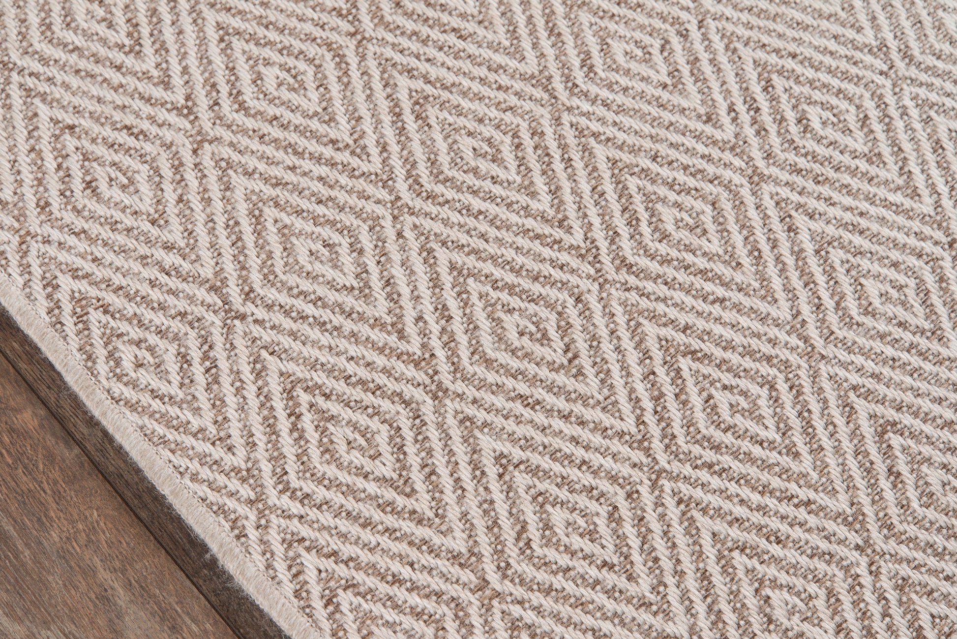 Beige and cream geometric diamond rug with textured weave; rectangular, indoor living room decor.