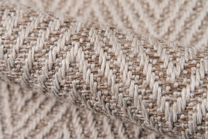 Beige woven rug close-up showing cream and tan yarns in a herringbone rib pattern.