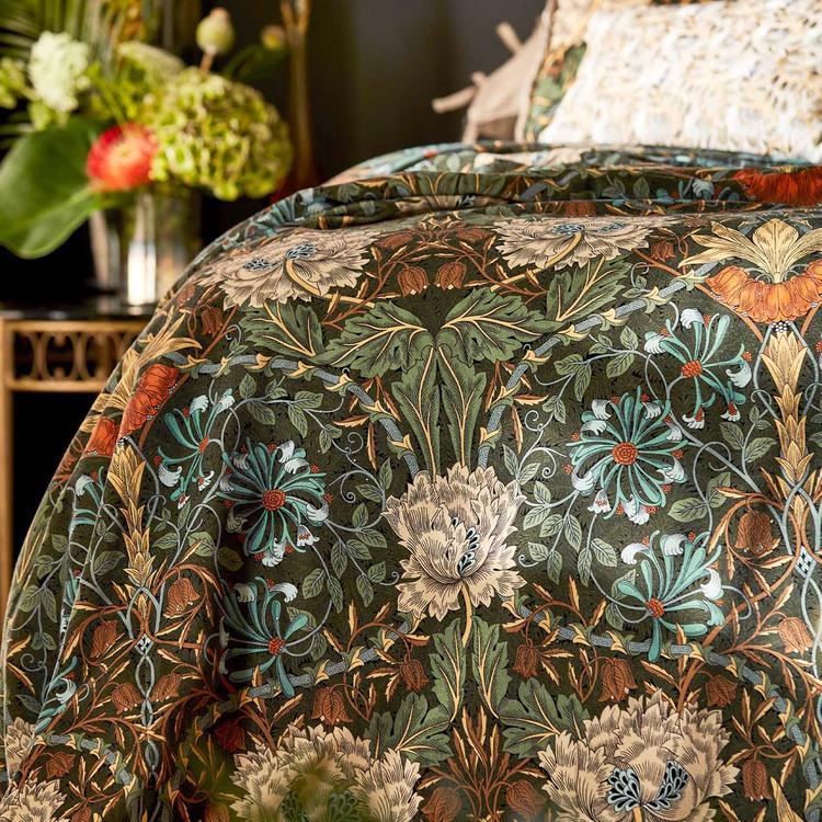Luxurious forest‑green and chestnut Morris & Co Honeysuckle & Tulip velvet fabric with a classic large‑scale trellis of stylised tulips and honeysuckle foliage, 52″/133 cm wide, cotton‑rich pile velvet ideal for upholstery, drapes, headboards and cushions.