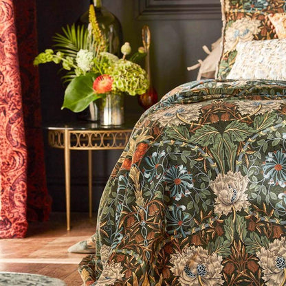 Luxurious forest‑green and chestnut Morris & Co Honeysuckle & Tulip velvet fabric with a classic large‑scale trellis of stylised tulips and honeysuckle foliage, 52″/133 cm wide, cotton‑rich pile velvet ideal for upholstery, drapes, headboards and cushions.