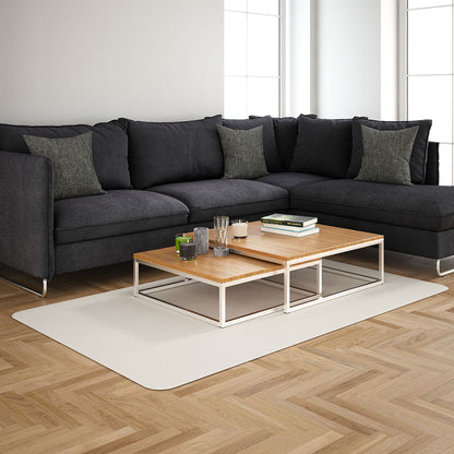 Dark gray L-shaped sectional sofa with matching cushions, two-tier light wood coffee table, white metal frame on beige rug.