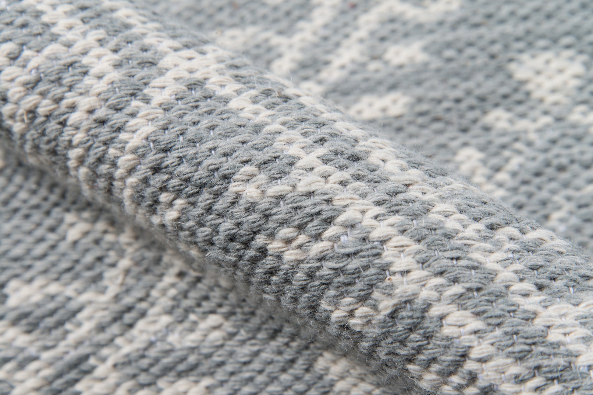 Close-up of gray and white woven rug with chunky knit texture, 2' x 3'.