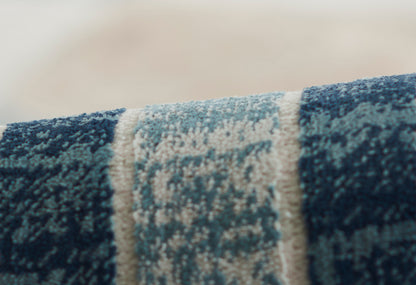 Blue woven rug close-up with ivory central stripe; plush pile, modern rustic style for living spaces.