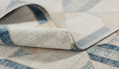 Close-up of a blue and cream woven rug with geometric diamond pattern and rolled edge.