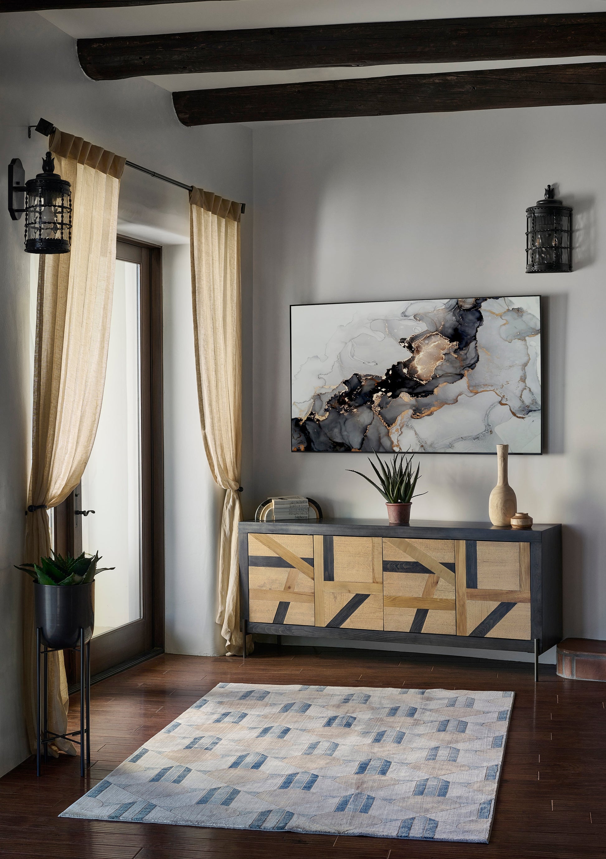 Geometric rug in neutral tones in a rustic-modern living room with beige curtains.