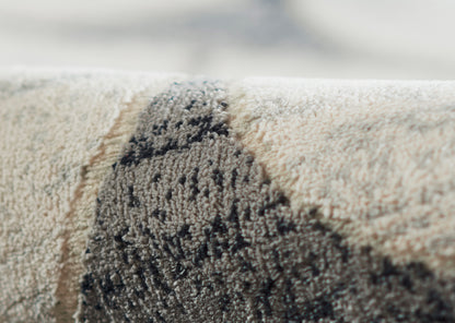 Close-up of a beige textured rug with a dark charcoal abstract pattern.