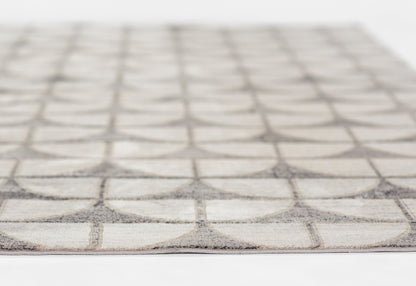 Beige flat-weave rug with grey circular lattice grid pattern, modern geometric decor.