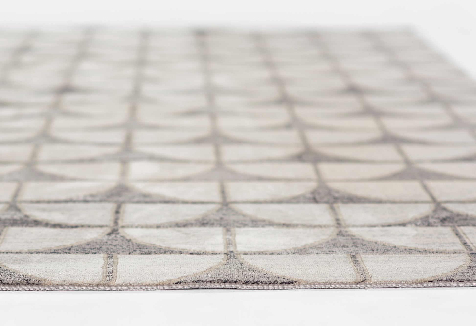 Cream and gray low-pile area rug with interlocking circle motif in a geometric pattern.