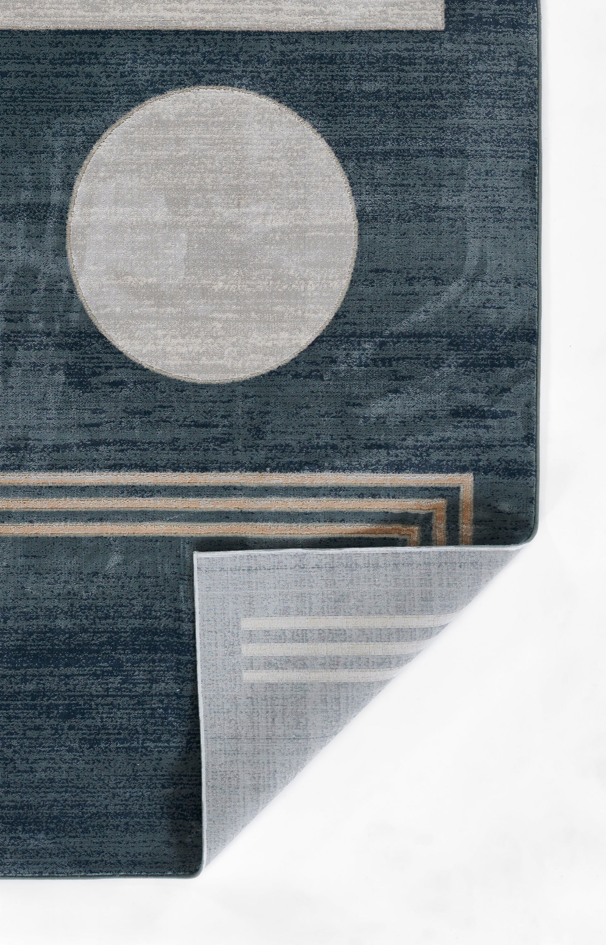 Dark blue geometric rug with a large light gray circle, beige stripes, and a folded corner revealing lighter backing.