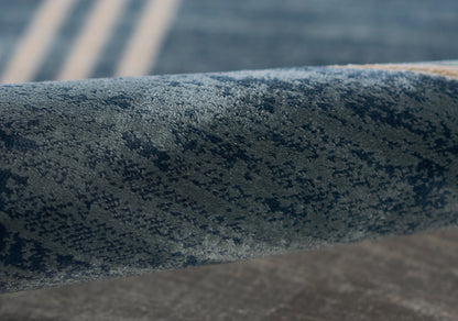 Close-up of a blue speckled cylindrical metal railing bar, powder-coated texture, curved, weathered industrial look.