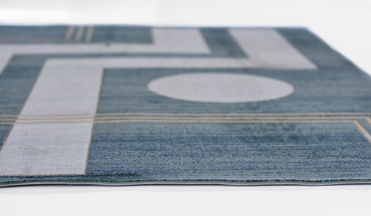 Blue and gray geometric area rug with circular motif and tan accents; modern abstract design.