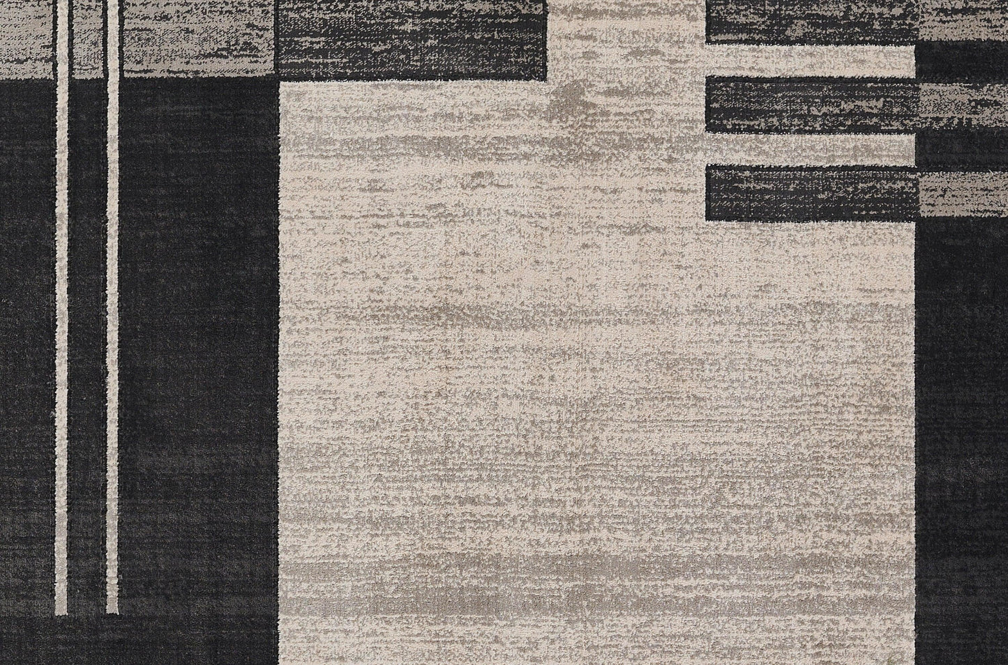 Abstract geometric area rug in black, charcoal gray and beige with vertical/horizontal blocks; modern textured layout.