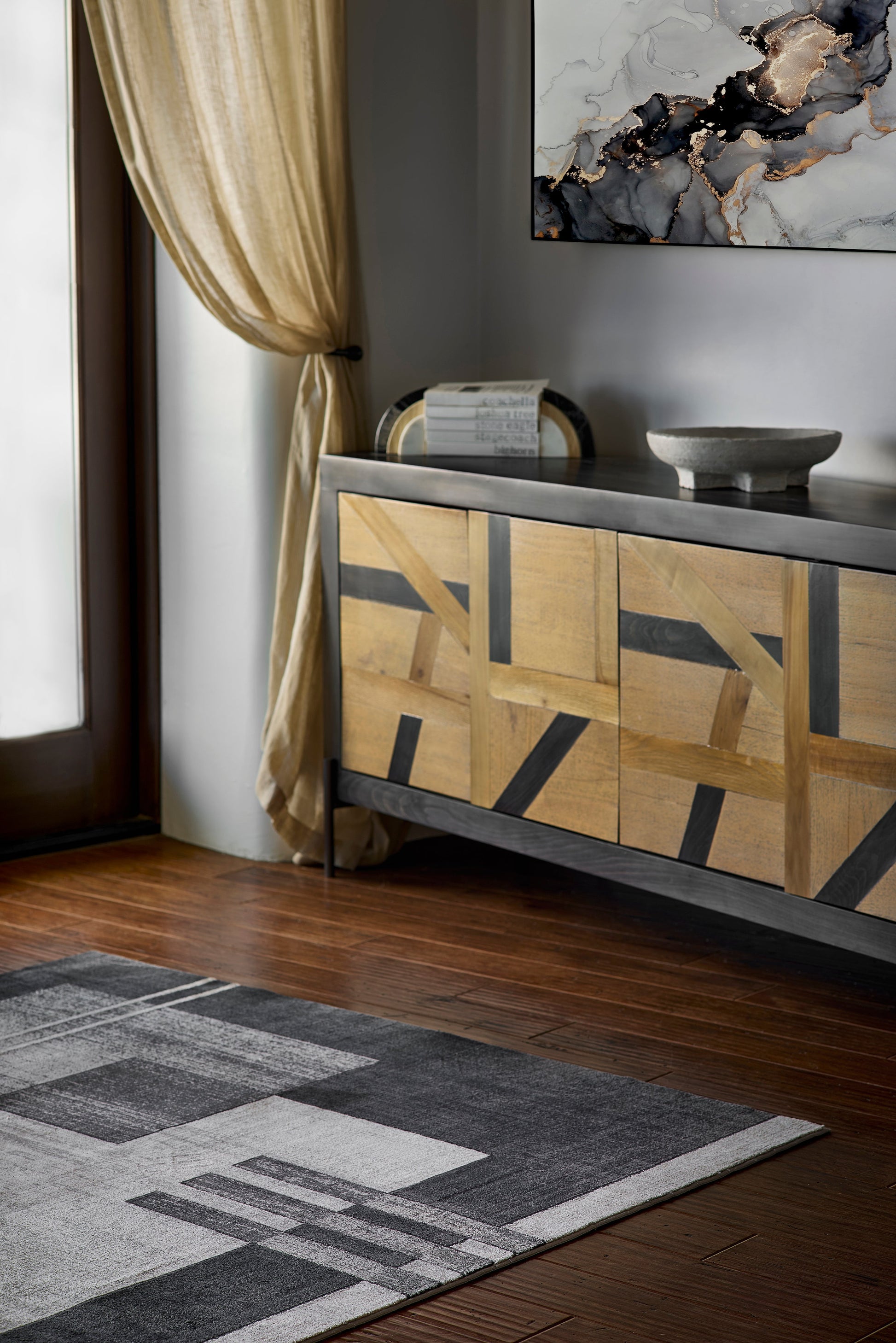 Geometric rug with a modern pattern, 2' x 3', shown in a living room.