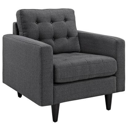Dark gray tufted fabric accent chair with buttoned back, wide arms, cushioned seat, and tapered black legs.