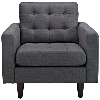 Dark gray fabric armchair with tufted back, square arms, cushioned seat and tapered wooden legs, mid-century modern.