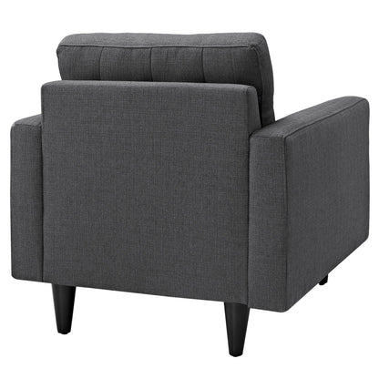 Dark gray fabric armchair with square arms, cushioned back, and black tapered legs; modern mid-century style.