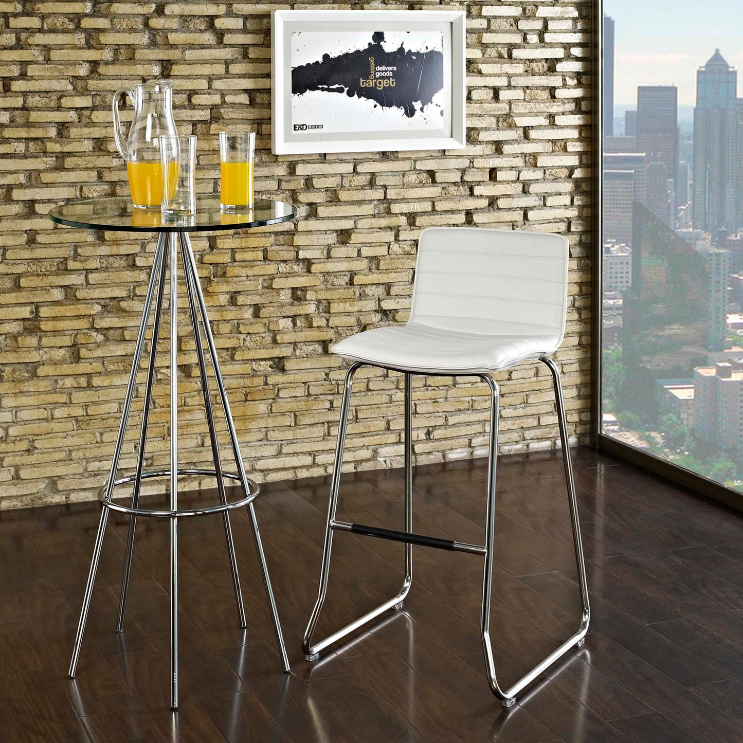 White bar stool with chrome legs beside a glass-top high table with orange juice; brick wall and city view.