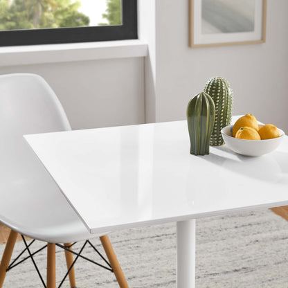 Glossy white rectangular dining table with white molded chair, cactus decor and a bowl of lemons.