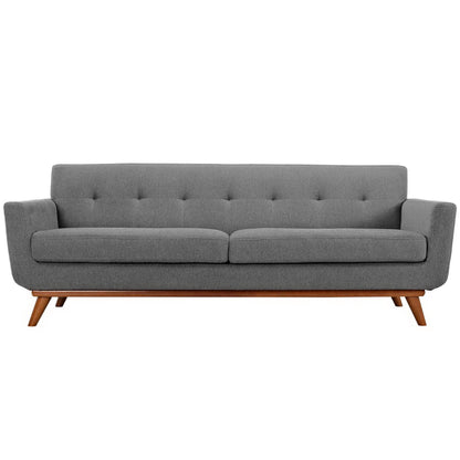 Grey mid-century fabric sofa with tufted back, two-seat cushions, rounded arms and wooden angled legs.
