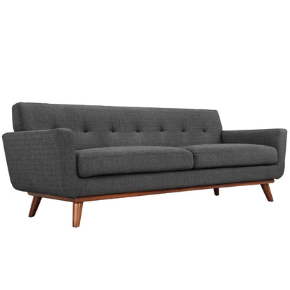 Dark gray fabric sofa in mid-century style with tufted back, two-seat cushions, and angled wooden legs.