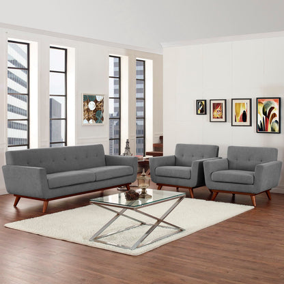 Gray mid-century sofa and two armchairs with wooden legs, glass coffee table on a cream rug in a modern living room.