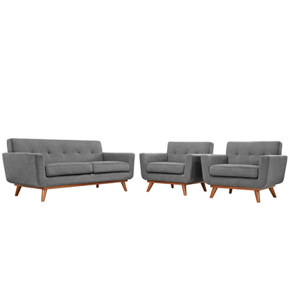 Gray mid-century modern sofa with tufted back cushions & tapered wooden legs, paired with two matching armchairs.
