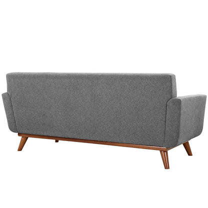 Gray fabric mid-century modern sofa with wooden angled legs, shown from the back.