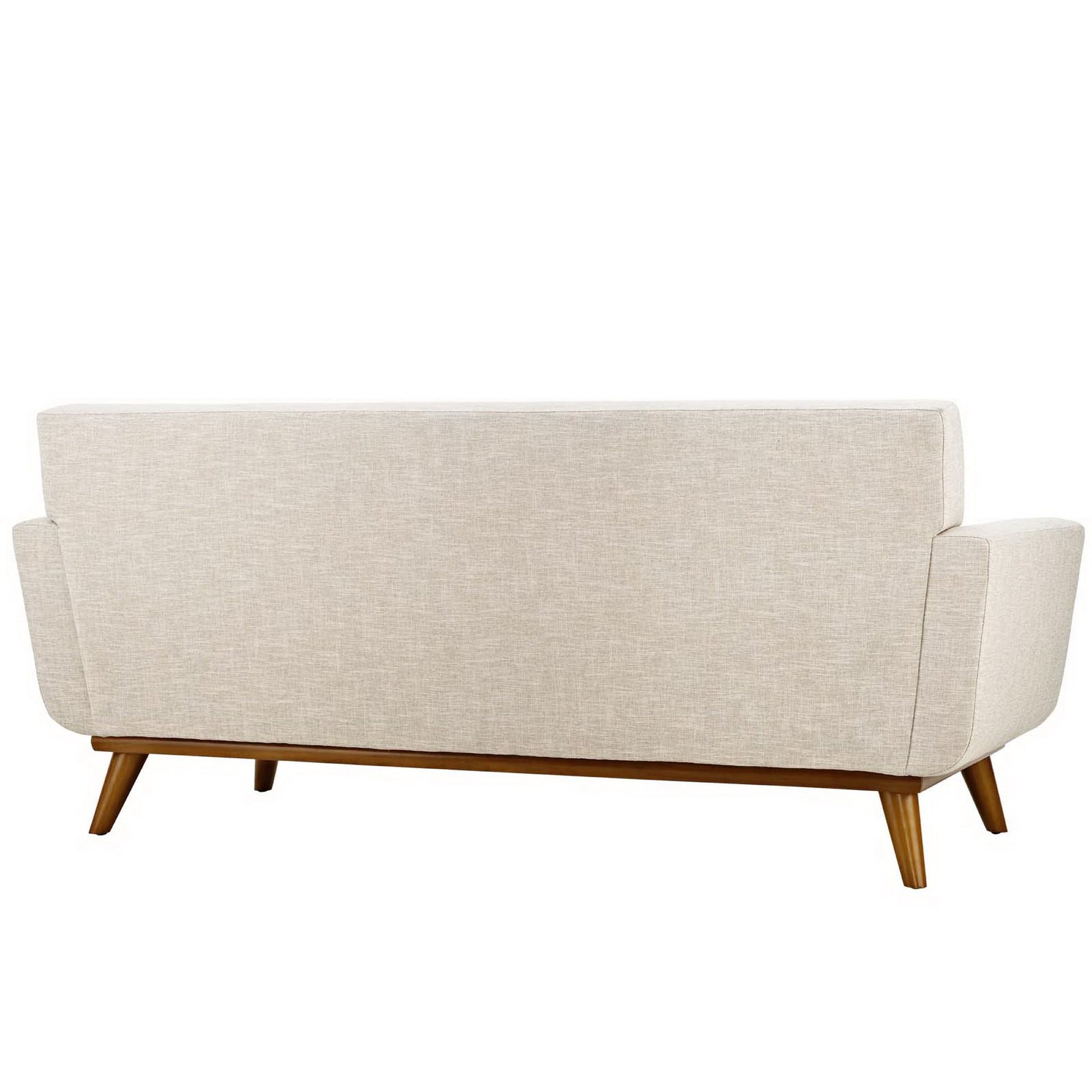 Beige fabric mid-century sofa seen from rear with tapered wooden legs and wood base rail.