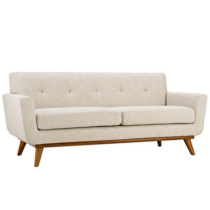 Beige fabric-upholstered mid-century modern sofa with tufted back, two seat cushions & angled wooden tapered legs.