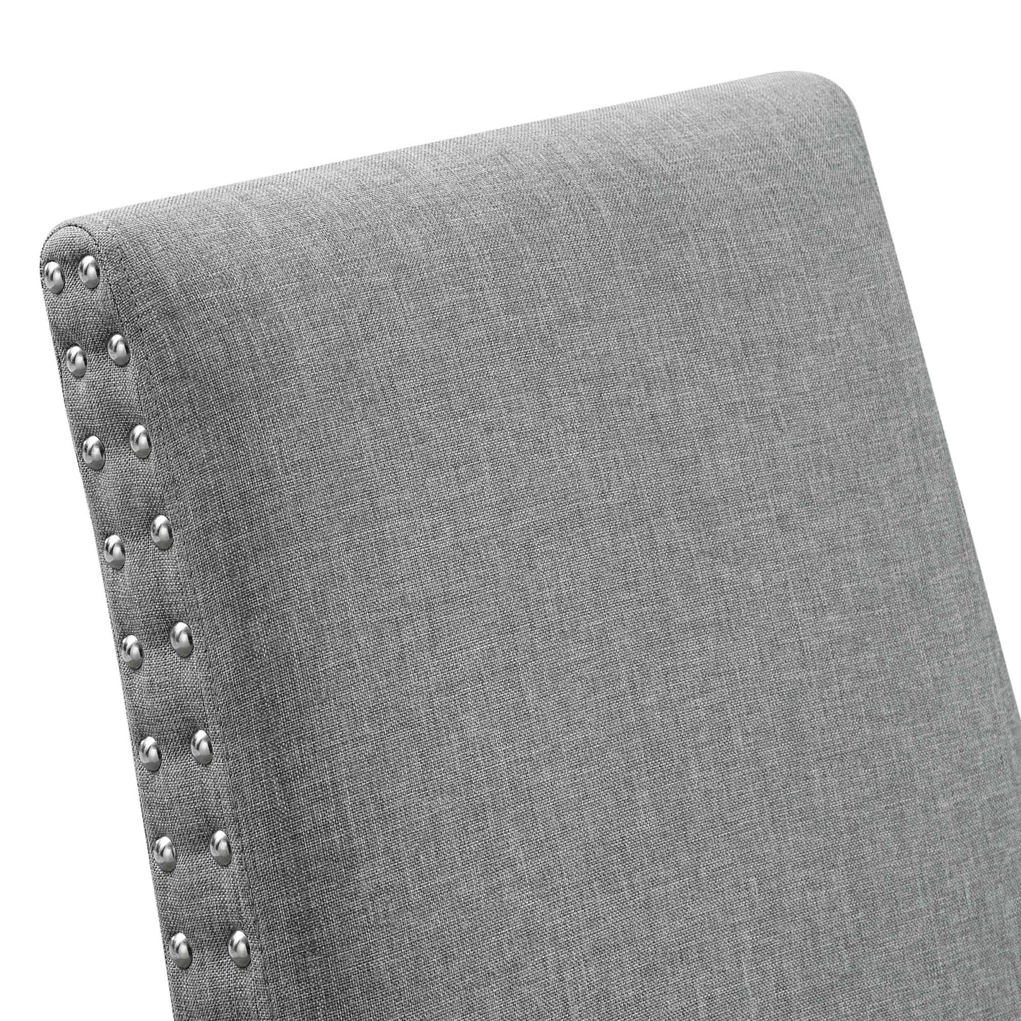 Gray fabric upholstered chair back with silver nailhead trim along the edge.