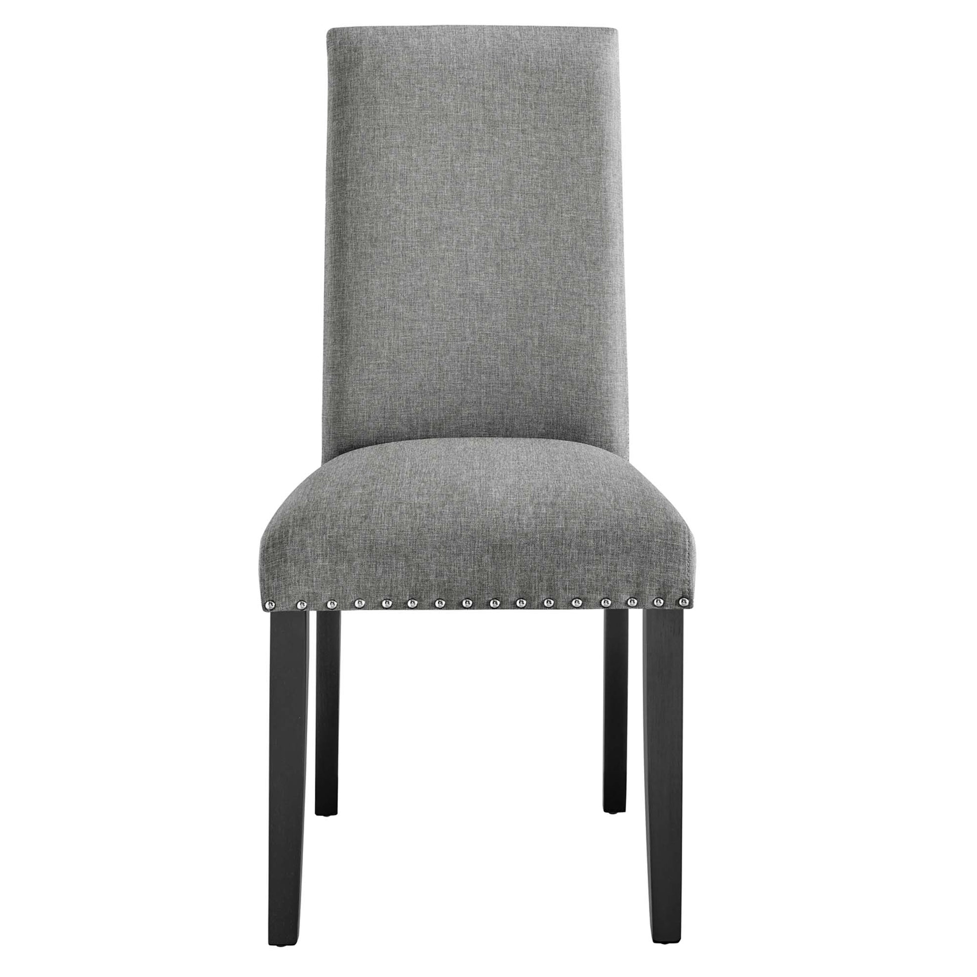 Grey fabric dining chair with tall back, curved padded seat, nailhead trim along rim, dark wooden legs.