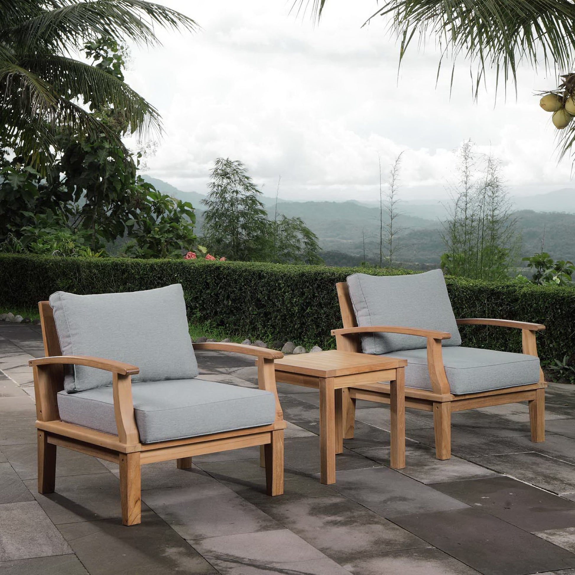 Natural wood outdoor set with two armchairs, curved arms, light gray cushions, and a matching side table.