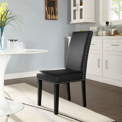 Black faux leather dining chair with nailhead trim and straight back, wooden legs, in a bright kitchen setting.