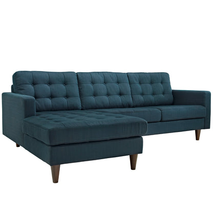 Teal-blue tufted fabric sectional sofa with chaise, mid-century wooden legs.