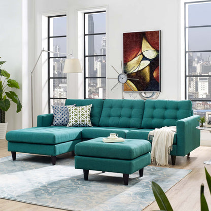 Teal sectional sofa with chaise and ottoman in a modern living room, abstract wall art, blue rug, city view.