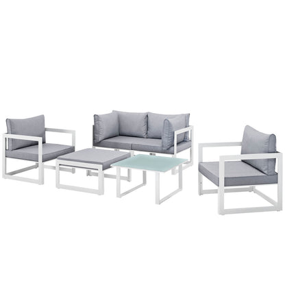 White metal outdoor sofa set with light gray cushions; 2 armchairs, 1 loveseat, and two glass-top tables.