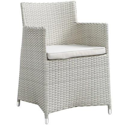 Gray woven synthetic wicker 7-piece outdoor dining set with white cushions and metal feet; modern patio furniture.