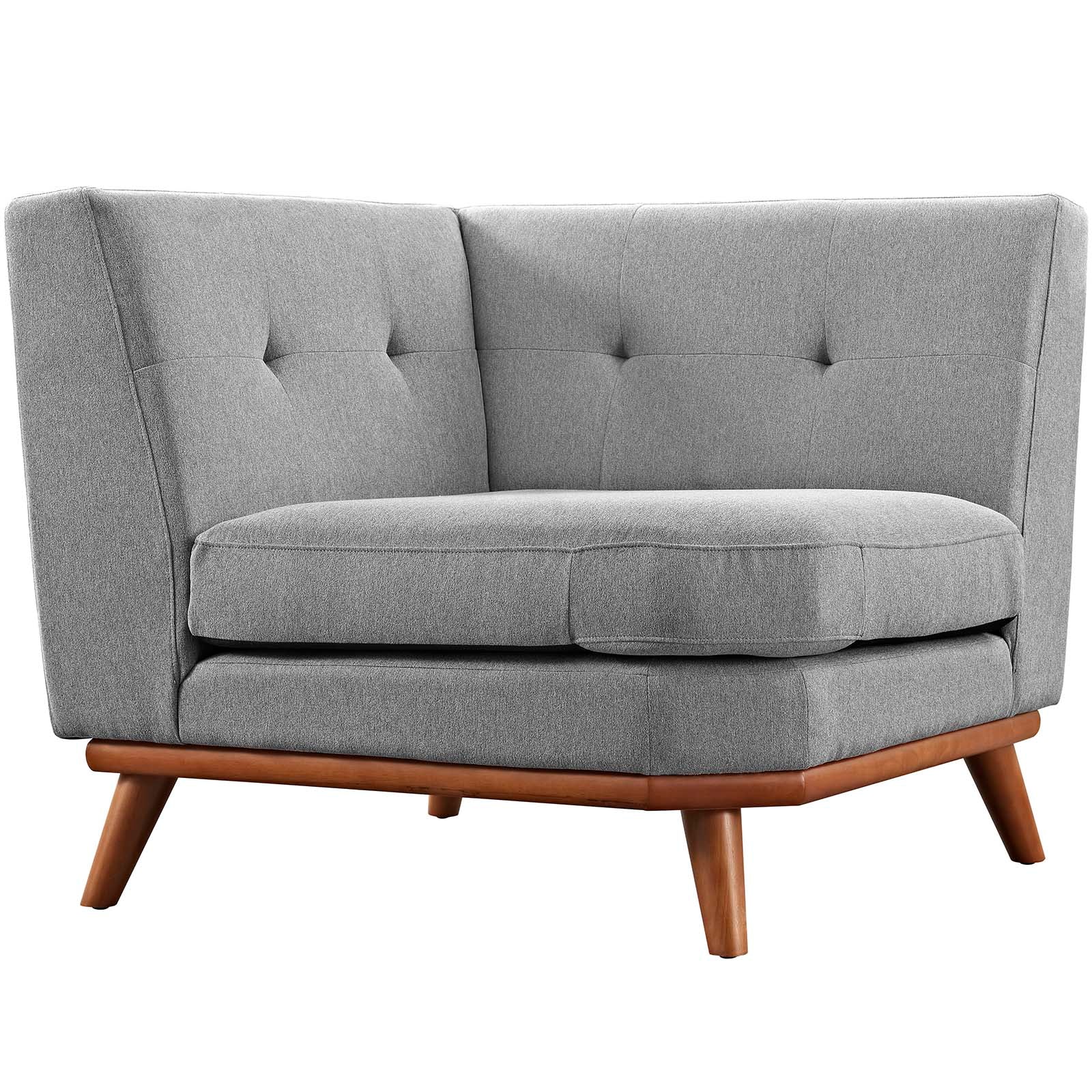 Grey fabric corner chair with tufted back and angled wooden legs.