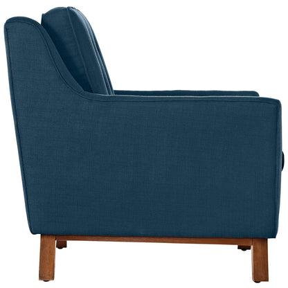 Blue fabric upholstered sofa with curved back and armrests, wooden legs, side profile.