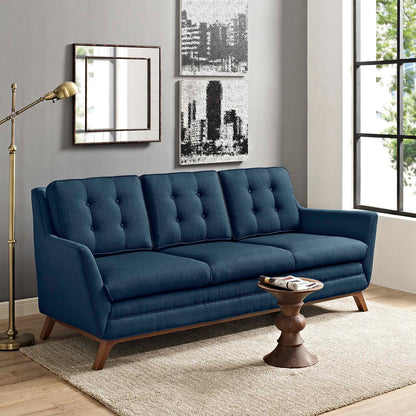 Azure blue tufted fabric sofa with wooden legs in a modern mid-century living room, beige rug, round wood coffee table.