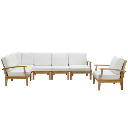 Teak outdoor sectional sofa with white cushions & left armchair, long central sectional & right armchair.