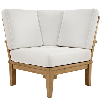 Natural wood outdoor corner chair with white seat cushion and three back cushions.