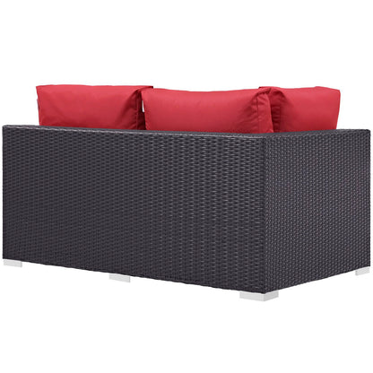 Dark wicker outdoor left-arm loveseat with red cushions; modern patio seating on metal feet.